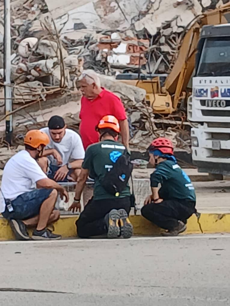 Integrantes de Humane World for Animals con cascos de rescate junto a escombros en Venezuela