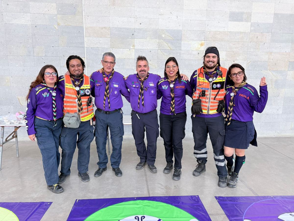 Equipo de scouts con camisa morada y chalecos de seguridad